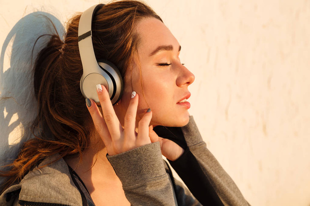 Close-up portrait of young pretty sport woman listening to music - Foto, imagen