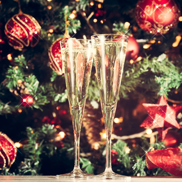 Two glasses of champagne with Christmas tree background and spar - Foto, imagen
