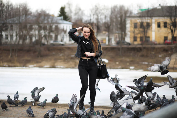 Girl on a walk in the park and a flock of pigeons - Photo, Image