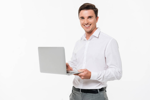 Retrato de un joven feliz sosteniendo ordenador portátil
 - Foto, Imagen