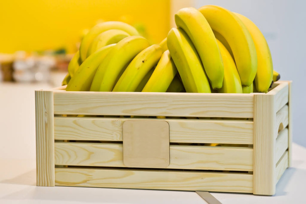 Bananas em uma caixa de madeira na mesa na cozinha
. - Foto, Imagem
