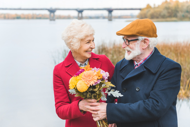 happy senior couple with bouquet - 写真・画像