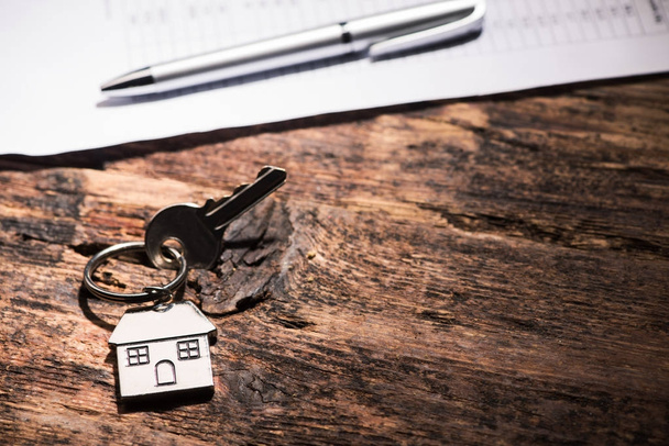Ключ от дома на деревянном столе
 - Фото, изображение