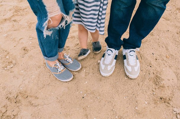 ноги батька, мати і маленька дівчинка
 - Фото, зображення