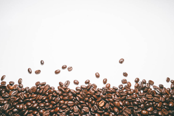 Braune Körner auf weißem Hintergrund, duftende Kaffeekörner, schönes Bild - Foto, Bild