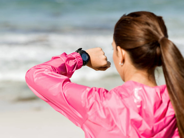 Woman in sportswear using smartwatch - Zdjęcie, obraz