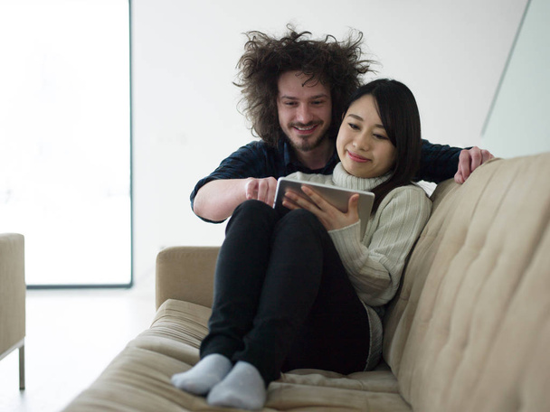 Jovem casal multiétnico relaxante em casa
 - Foto, Imagem