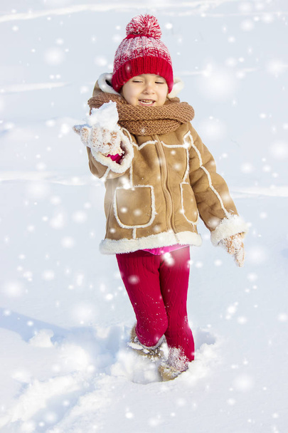 Een kind speelt in de sneeuw in de winter. Selectieve aandacht. - Foto, afbeelding