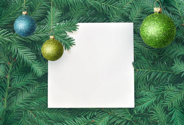 Fundo criativo de ramo de pinheiro com cartão de papel branco. Ano Novo e conceito de Feliz Natal
. - Foto, Imagem