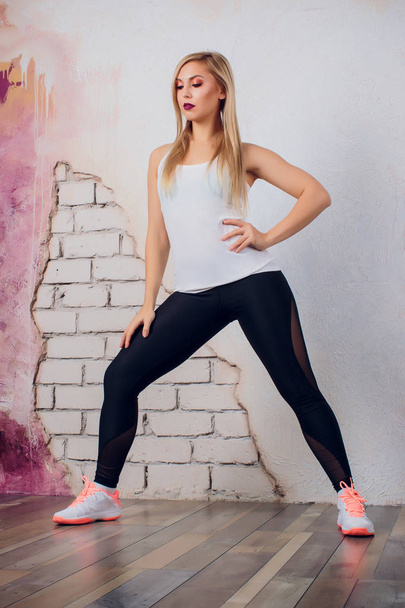 young blonde girl woman fitness trainer shows exercise pose - Fotografie, Obrázek
