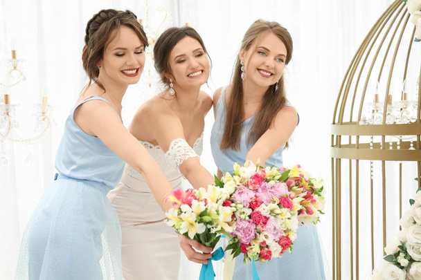 Happy beautiful bride with bridesmaids on wedding day, indoors - Photo, image