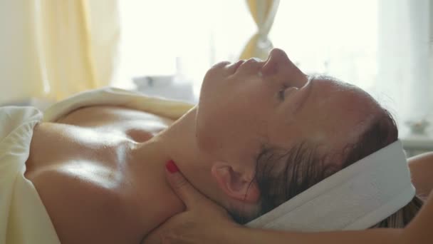 Atrakcyjna kobieta w klubie zdrowia spa, masażu twarzy - Materiał filmowy, wideo