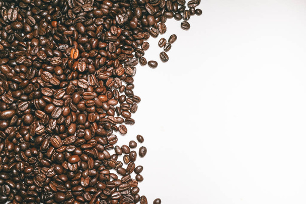 brown grains on a white background, fragrant coffee grains, beautiful picture - Foto, afbeelding