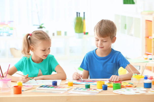 Cute children painting pictures at table indoors - Photo, image