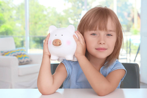 little girl with piggy bank  - Фото, изображение