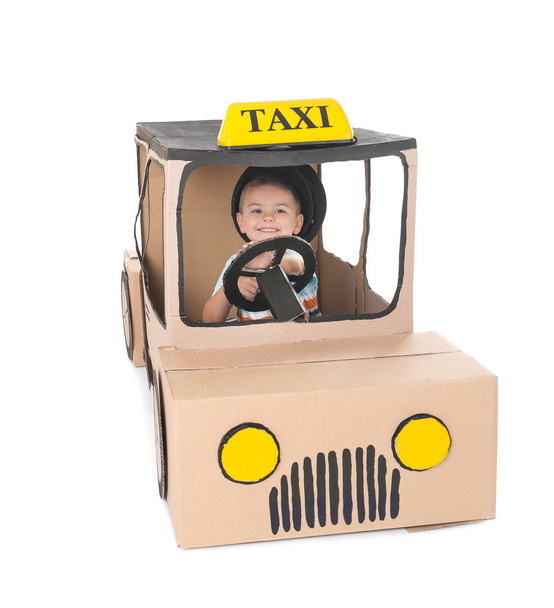 Little boy playing with cardboard taxi on white background - 写真・画像