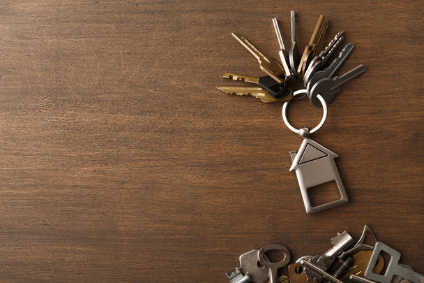 Bunch of keys with house trinklet on wooden table - Photo, Image