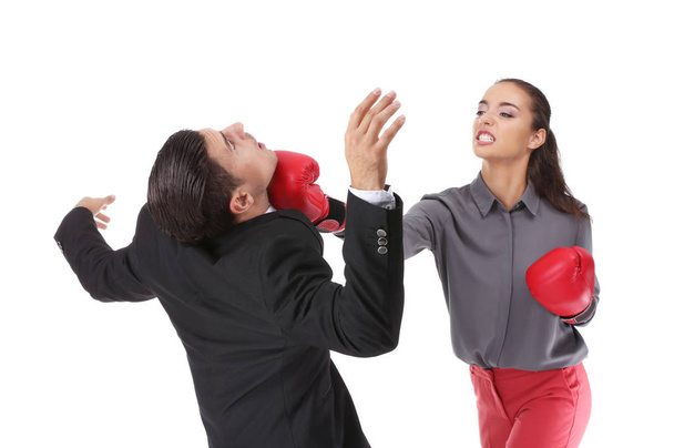 Woman in boxing gloves hitting businessman - Zdjęcie, obraz