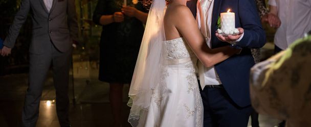 Gyertya kezében a menyasszony és a vőlegény az esküvőn - Fotó, kép