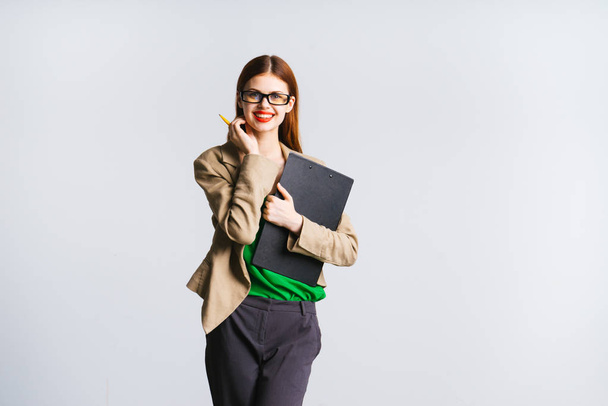stylish happy girl with glasses and with red lipstick smiles, holds a folder with documents - Foto, imagen