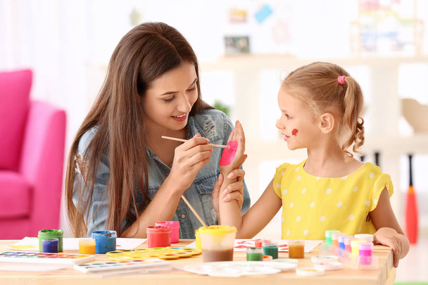 Cute girl with mother painting at table indoors - Foto, immagini