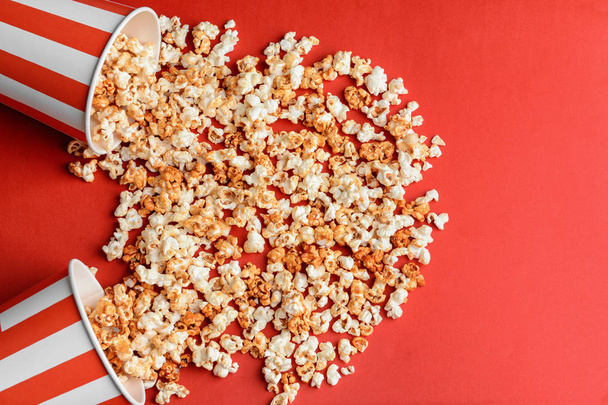 Overturned cups with tasty caramel popcorn  - Foto, afbeelding