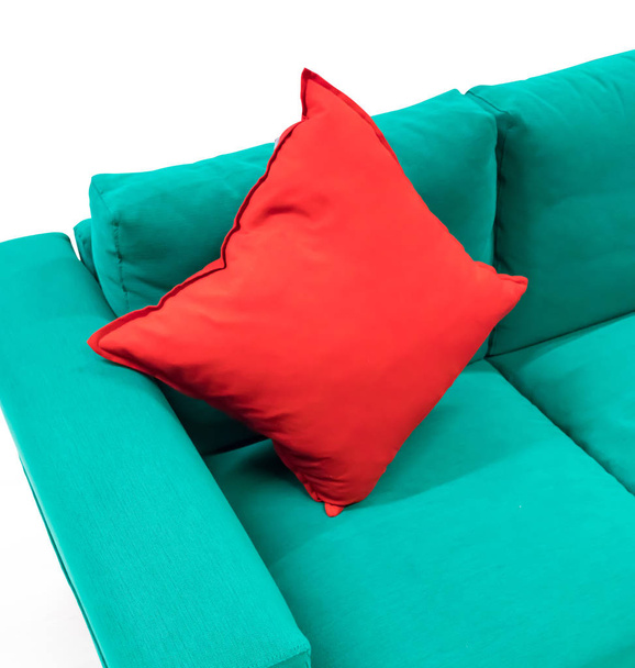 Almohada cuadrada de algodón rojo sobre sofá de tela verde aislado
 - Foto, Imagen