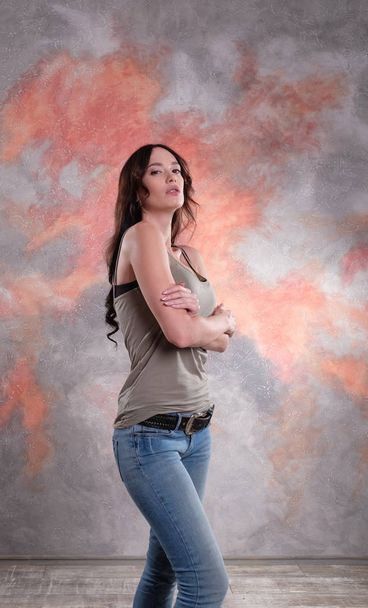 Stunning woman studio shot. Wearing t-shirt and jeans. - Фото, зображення