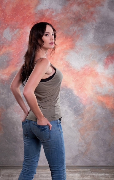 Stunning woman studio shot. Back view with hands in pockets. - Foto, immagini