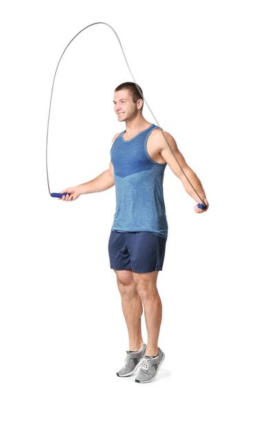 Young man with jumping rope on white background - Φωτογραφία, εικόνα