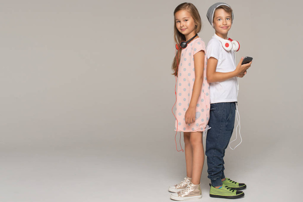 dívka a chlapec se sluchátky a smartphone - Fotografie, Obrázek