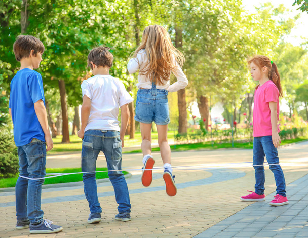 Cute little children jumping rope in park - Fotografie, Obrázek