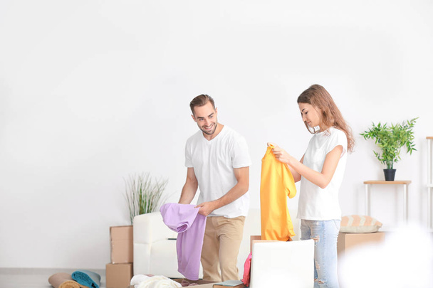 Young couple unpacking moving boxes at new home - Φωτογραφία, εικόνα