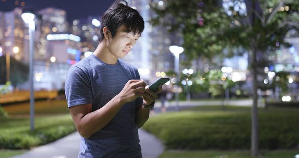 Joven envío de SMS en el teléfono celular
  - Foto, imagen