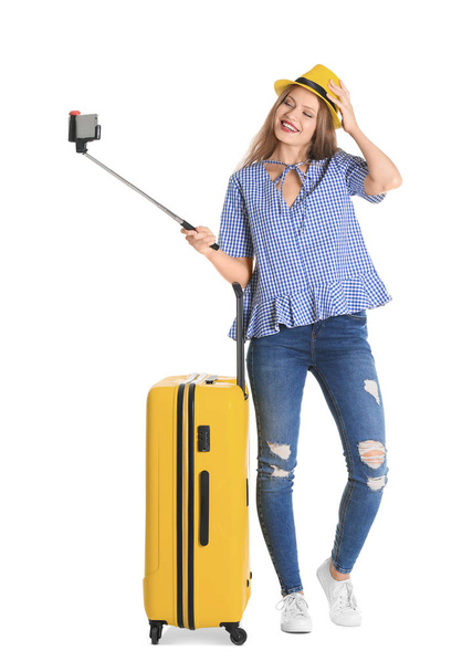 Attractive female tourist taking selfie on white background - Photo, image