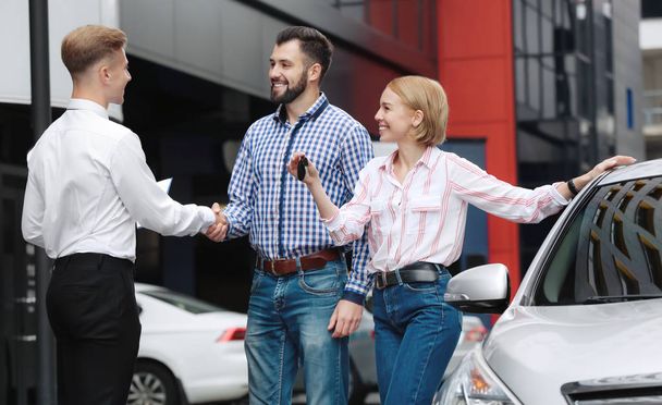 Young couple with car dealer outdoors - Fotografie, Obrázek