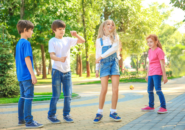 Cute little children jumping rope in park - Φωτογραφία, εικόνα
