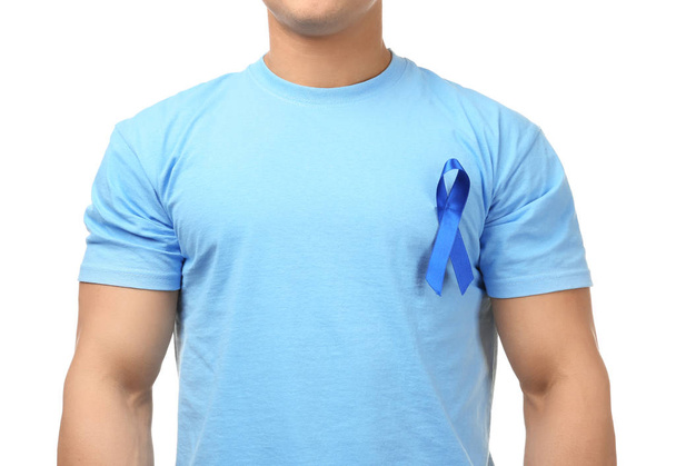 Young man wearing t-shirt with blue ribbon on white background. Prostate cancer awareness concept - Fotoğraf, Görsel