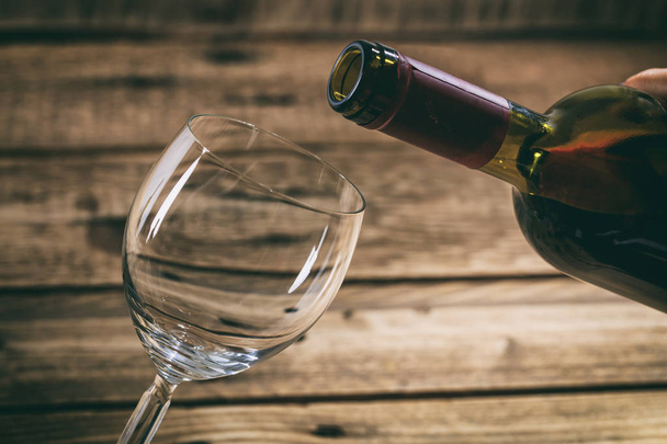 Наливание вина в стакан на деревянном фоне
 - Фото, изображение