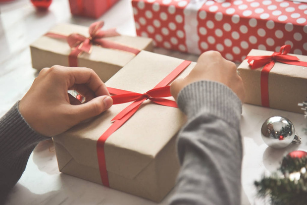 Female hands wrapping a brown present box. - Foto, Imagem