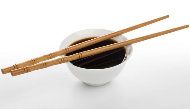 Soy sauce and chopsticks isolated on white background - Photo, Image