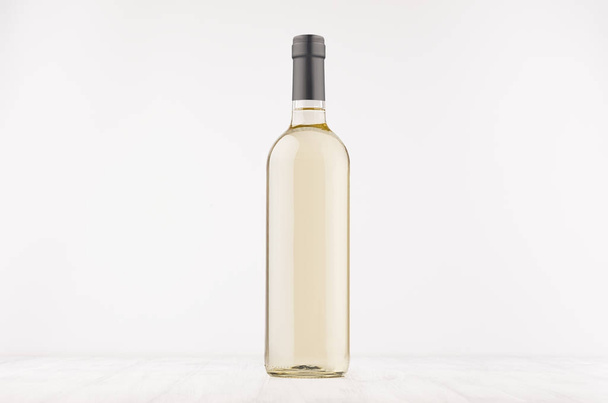 Przezroczyste butelki wina z białego wina na biały deska drewniana, makieta. - Zdjęcie, obraz