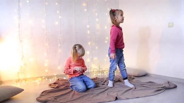 Dwie małe dziewczynki siedzą na podłodze i grać. - Materiał filmowy, wideo