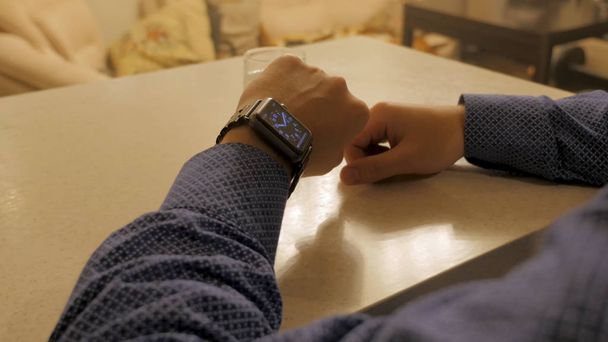 Handsome stylish male managing time on electronic watch. Young man checking modern wrist clock - 写真・画像