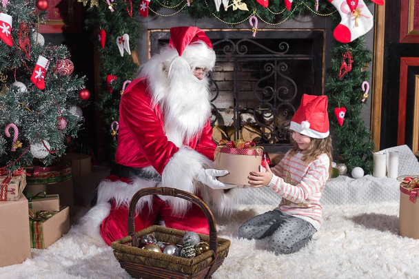 Santa Claus and cute girl getting ready for Christmas. - Фото, зображення