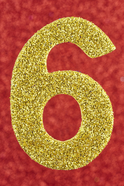 Αριθμός έξι χρυσό χρώμα πάνω σε κόκκινο φόντο. Επέτειος.  - Φωτογραφία, εικόνα
