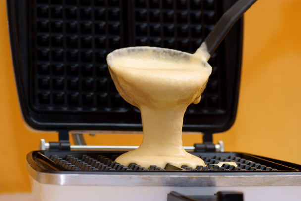 Prensa de massa waffle em uso na cozinha moderna
 - Foto, Imagem