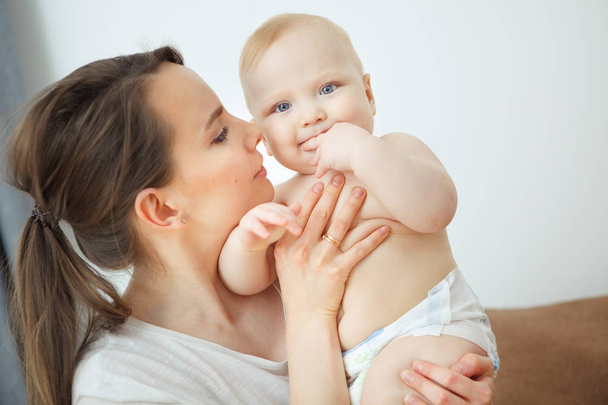 Mother hugs baby toddler smelling his tasty body, happy moments - Fotografie, Obrázek
