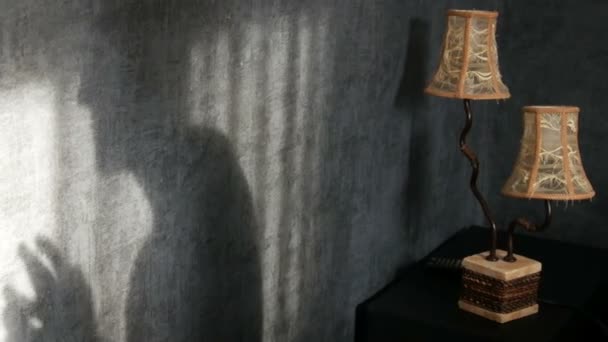 schrecklicher Schatten in einem gotischen dunklen Raum neben einer gelben Vintage-Lampe, bedrohlich fingernd. ein Gespenst oder eine Hexe zu Halloween. - Filmmaterial, Video