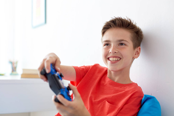 happy boy with gamepad playing video game at home - Foto, Imagem